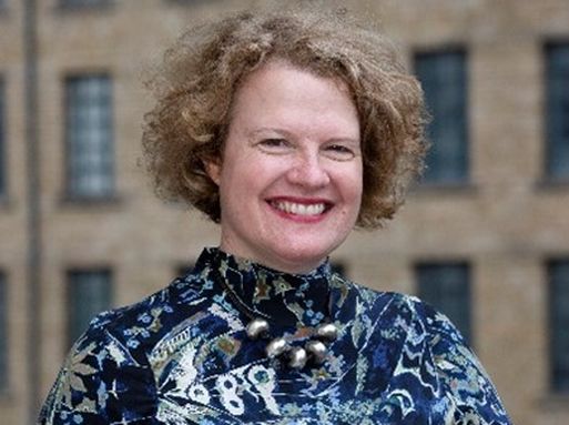 Nicola Gray, a white woman with short light brown curly hair