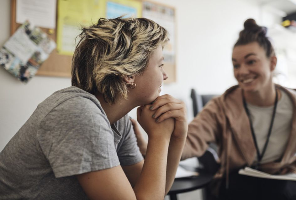 Photo of a healthcare worker performing a public health intervention with a teenager