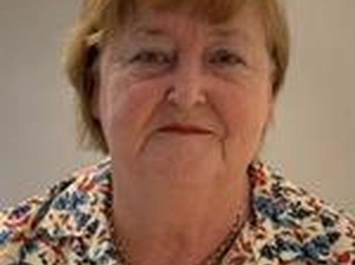 Susanne Surman-Lee, a white woman with blonde hair wearing a floral blouse