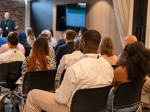 A view from the back of an RSPH event, where RSPH Members are sat in rows listening to someone talk.